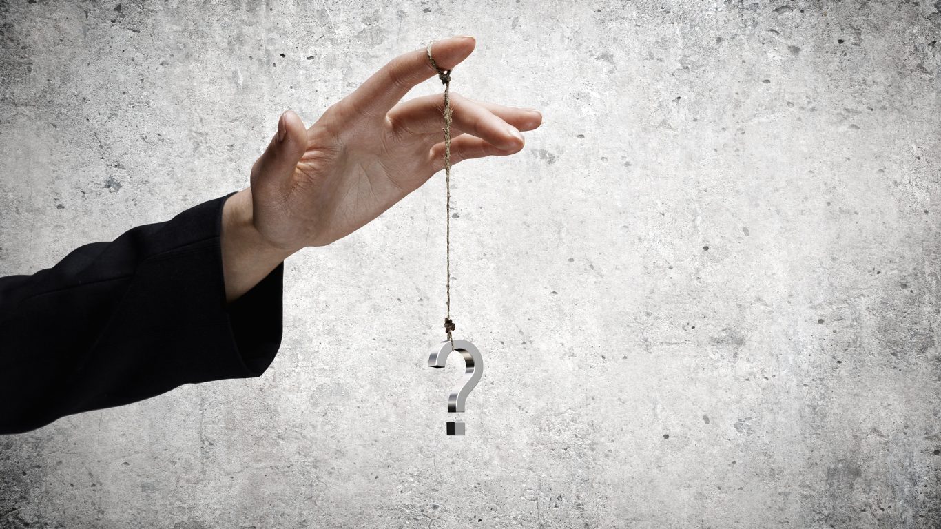 Hand dangling a metal hook with a question mark at the end, symbolizing inquiry, curiosity, or the search for answers about digital marketing, fractional cmo, or entrepreneur.